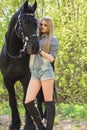 Beautiful brunette girl with long hair posing with a red horse in forest Royalty Free Stock Photo