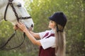 Beautiful brunette girl with long hair posing with a red horse in forest Royalty Free Stock Photo