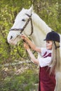 Beautiful brunette girl with long hair posing with a red horse in forest Royalty Free Stock Photo