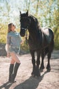 Beautiful brunette girl with long hair posing with a red horse in forest Royalty Free Stock Photo