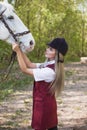 Beautiful brunette girl with long hair posing with a red horse in forest Royalty Free Stock Photo