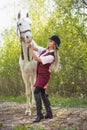 Beautiful brunette girl with long hair posing with a red horse in forest Royalty Free Stock Photo