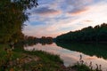 Autumn landscape, beautiful sunset and bright colorful forest in the evening, trees near river and blue sky Royalty Free Stock Photo