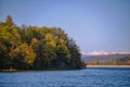 Autumn landscape with a blue lake and mountains in the background. Colorful forest at the edge of the water Royalty Free Stock Photo