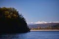 Autumn landscape with a blue lake and mountains in the background. Colorful forest at the edge of the water Royalty Free Stock Photo