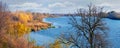 Autumn landscape with blue river and dry tree by the river on a sunny day Royalty Free Stock Photo