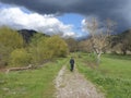 Autumn landscape with a boy walking in a field under heavy clouds.