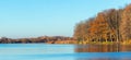 Autumn landscape with colorful trees in the forest by the river and blue sky in sunny weather Royalty Free Stock Photo