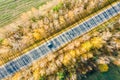 Autumn landscape with country road among yellow trees with long shadows. aerial view from flying drone Royalty Free Stock Photo