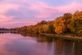 Autumn landscape. Fantastic dramatic colorful flaming sky, trees and reflections in the lake after amazing sunset in the park. Royalty Free Stock Photo