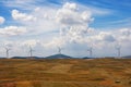 Autumn landscape. Golden field, blue sky and line of windmills. Montenegro, Krnovo wind park