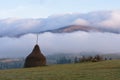 Autumn landscape with haystacks and fog in the mountains Royalty Free Stock Photo