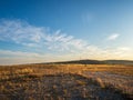 Autumn landscape. High blue sky with clouds on a deserted clearing covered with wild yellowed grasses Royalty Free Stock Photo