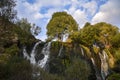 Autumn landscape with High rocky waterfall Shaki flowing between large green trees and mossy rocks. Armenia Royalty Free Stock Photo