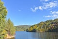 Autumn landscape with a lake in the forest, trees and blue sky, Royalty Free Stock Photo