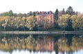 Autumn landscape with willow trees next to a lake