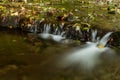 Autumn landscape with mountain river flowing among mossy stones through the colorful forest. Silky smooth stream of clear water. Royalty Free Stock Photo