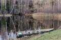 Autumn landscape. Old wooden boat moored to shore of calm lake surrounded by forest. Royalty Free Stock Photo