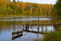 Autumn landscape. Old wooden bridge with handrail on the lake shore Royalty Free Stock Photo