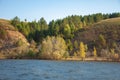 Autumn landscape,   river, windy weather, dark blue water, yellow-red autumn leaves on trees, last warm days Royalty Free Stock Photo