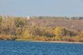 Autumn landscape,  river, windy weather, dark blue water, yellow-red autumn leaves on trees, last warm days Royalty Free Stock Photo