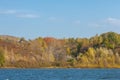 Autumn landscape,  river, windy weather, dark blue water, yellow-red autumn leaves on trees, last warm days Royalty Free Stock Photo