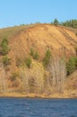 Autumn landscape,   river, windy weather, dark blue water, yellow-red autumn leaves on trees, last warm days Royalty Free Stock Photo