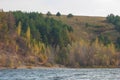 Autumn landscape, river,   windy weather, dark blue water, yellow-red autumn leaves on trees, last warm days Royalty Free Stock Photo