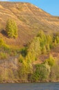 Autumn landscape, river,   windy weather, dark blue water, yellow-red autumn leaves on trees, last warm days Royalty Free Stock Photo