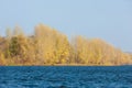 Autumn landscape,   river, windy weather, dark blue water, yellow-red autumn leaves on trees, last warm days Royalty Free Stock Photo