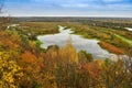 Autumn landscape: trees with yellow leaves grow on the banks of a cold autumn river amid dark skies Royalty Free Stock Photo