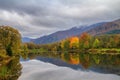 Autumn landscape - view of the lake with the reflection of autumn trees in the mountains