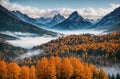 Autumn landscape - view of a wooded river valley with morning fog surrounded by snowy mountains Royalty Free Stock Photo