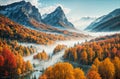 Autumn landscape - view of a wooded river valley with morning fog surrounded by snowy mountains Royalty Free Stock Photo