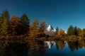 Autumn larches against the background of the Matterhorn and autumn in the Alps. The clear water of the mountain lake