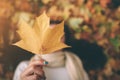 A young black-haired woman is holding Autumn Leaf. autumn leaves in a park. Royalty Free Stock Photo