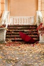 Autumn leaf fall. Red and yellow leaves on the destroyed old stone steps burgundy (marsala color) umbrella. Royalty Free Stock Photo