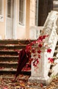 Autumn leaf fall. Red and yellow leaves on the destroyed old stone steps burgundy (marsala color) umbrella. Royalty Free Stock Photo