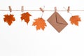 Autumn leaves background, fallen maple leaves hanging on clothespins on a rope with craft envelope, concept of autumn discounts an