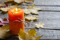 Autumn Leaves And Candle On Wooden Boards Background