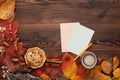 Autumn leaves, cookies, tea and greeting card on wooden background Royalty Free Stock Photo