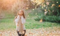 Autumn leaves falling on happy young woman in forest. Portrait of very beautiful girl in fall park