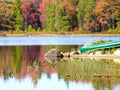 Autumn leaves over a lake with canoe