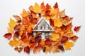 autumn leaves pieced together to form a house on white paper