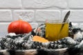 Autumn leaves, pumpkin, a cup of green tea wrapped in a motley black and white scarf. A woolen scarf keeps tea warm