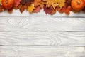 Autumn leaves and pumpkins over old wooden background