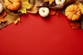 Autumn leaves, pumpkins, plaid on red background. Flat lay, top view. Autumn frame Royalty Free Stock Photo