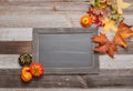 Autumn leaves, pumpkins on wooden background with copy space on chalkboard Royalty Free Stock Photo