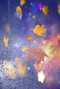 Autumn leaves rain drops on window glass bokeh street evening light nature weather forecast Royalty Free Stock Photo