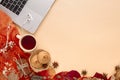 Autumn leaves, scarf, paper notebook and laptop on yellow background